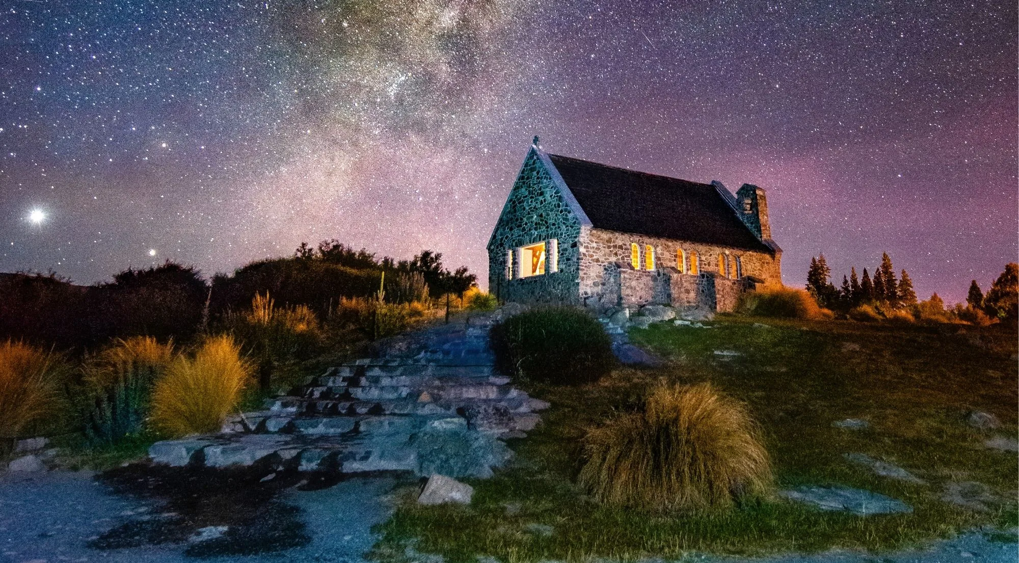 Stone path to the Church of the Good Shepherd lit under a starry sky