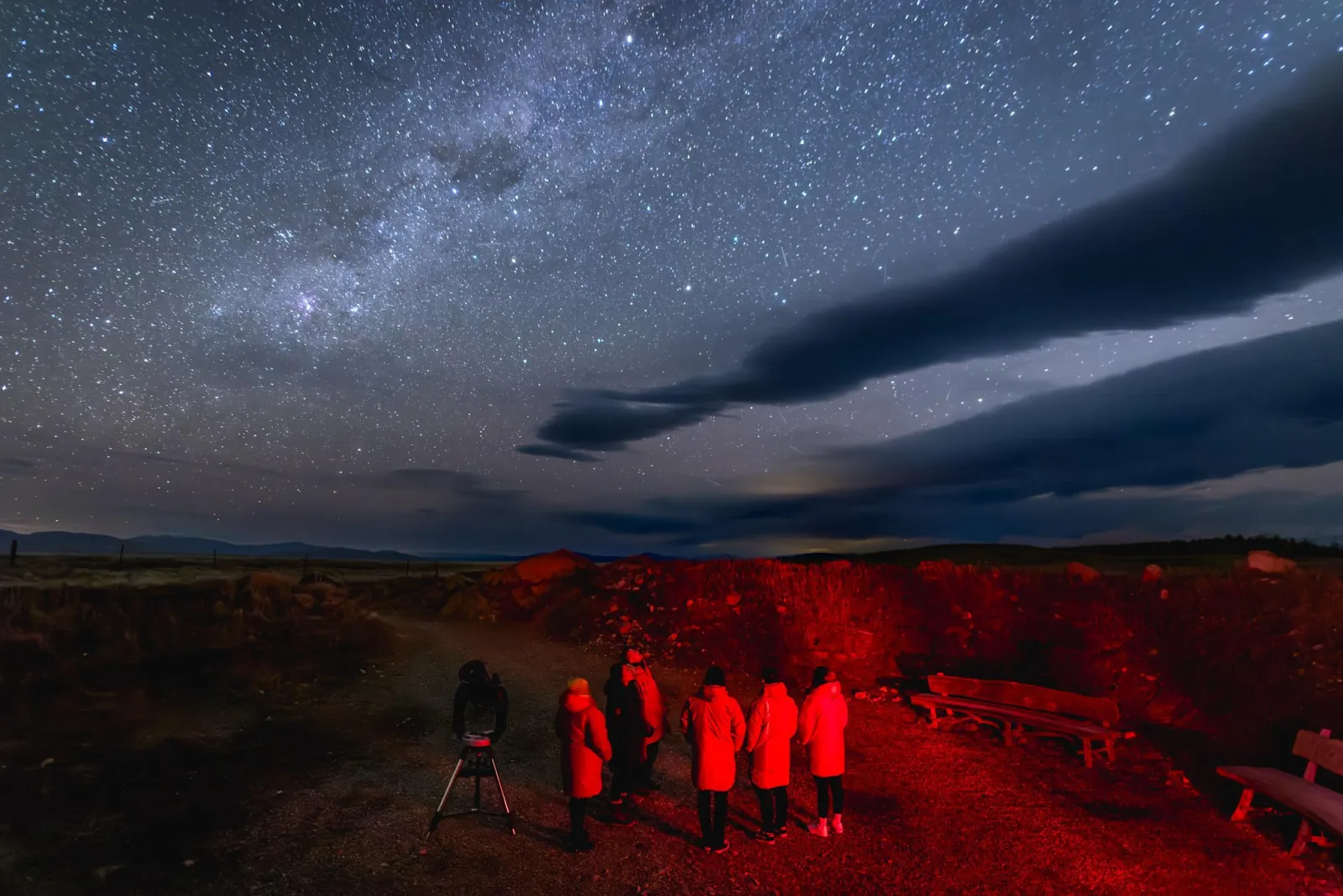 Guests in red light walking to the viewing crater at Cowan's Observatory