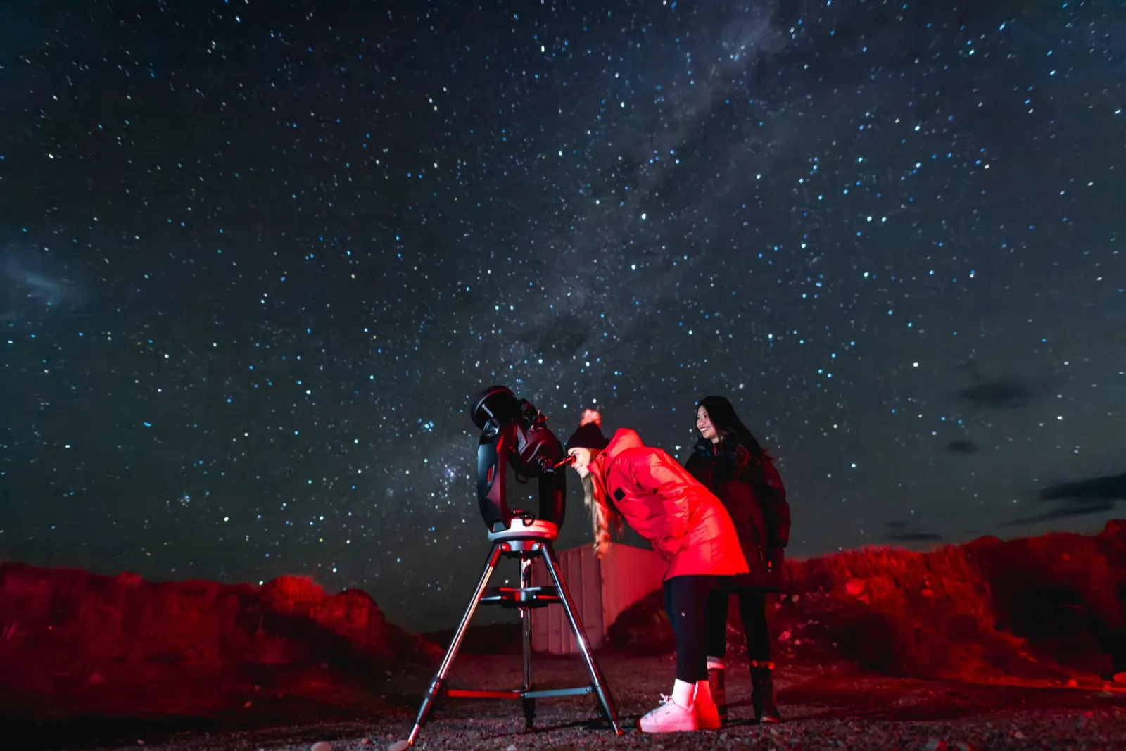 Guest looking through a telescope in the viewing crater at Cowan's