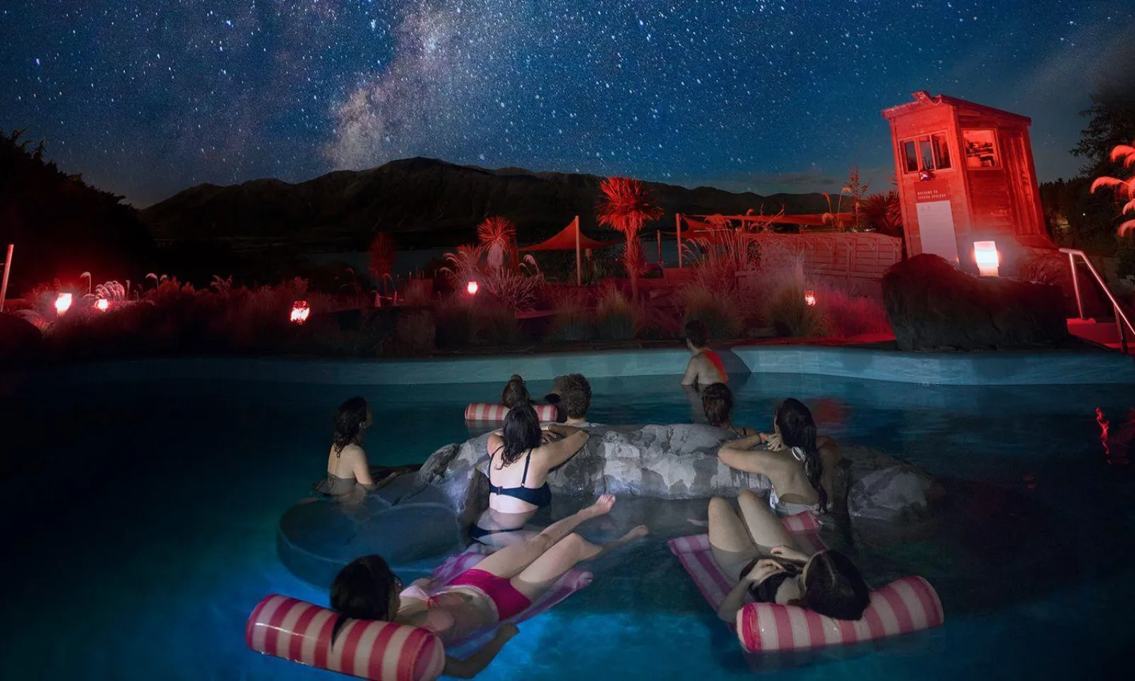 Guests floating in hammocks in a hot pool under the stars at Tekapo Springs