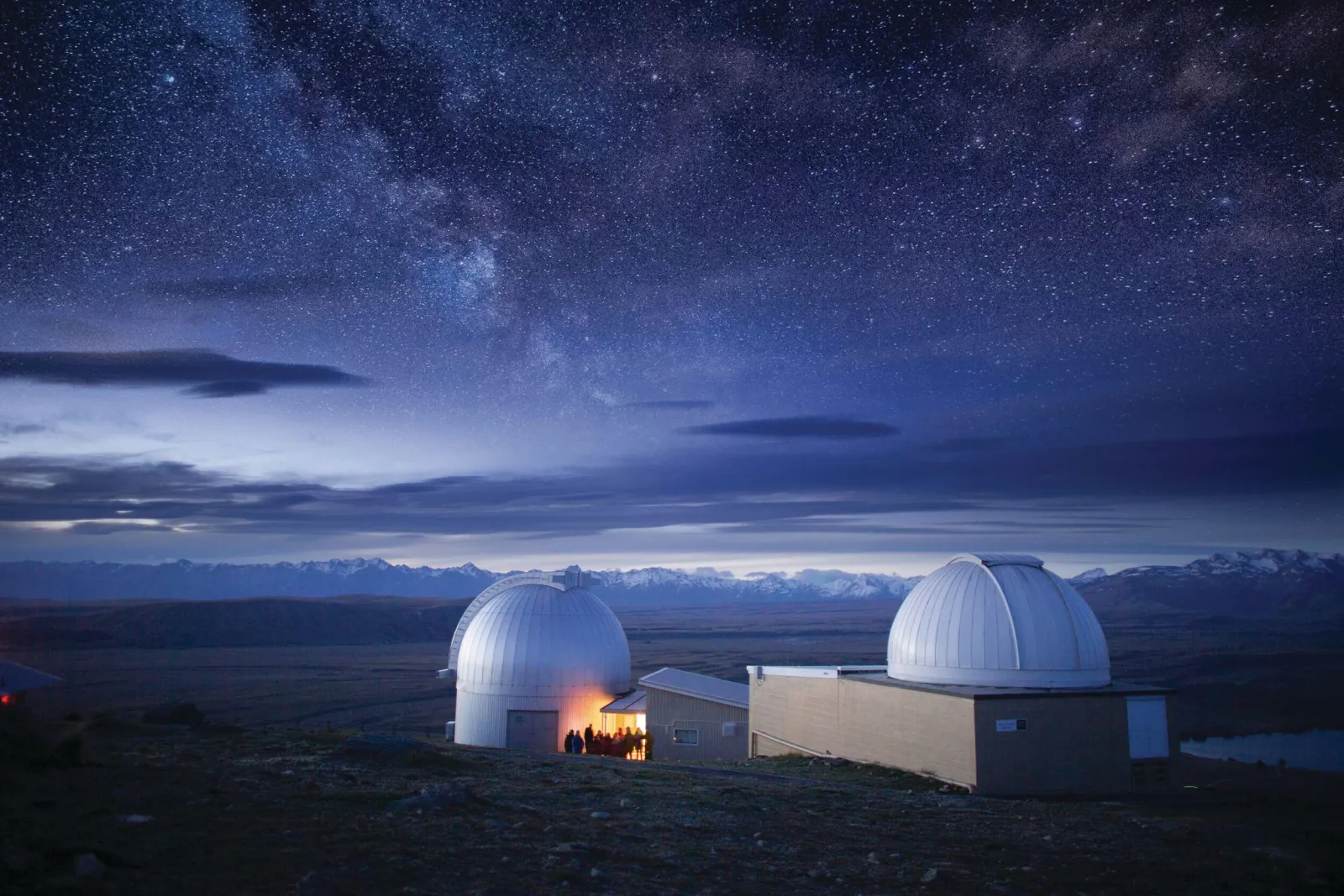 Mount John Observatory domes lit at dusk above Lake Tekapo