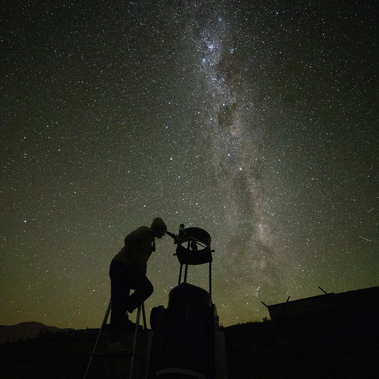 Guide at a telescope under the Milky Way on the high-country station